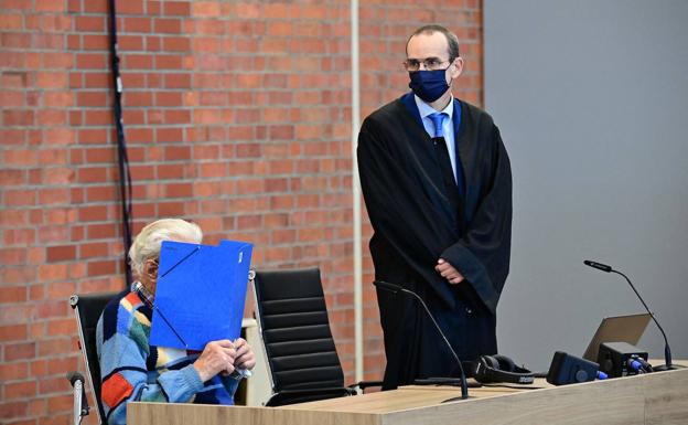 Josef S., en la sala de vistas, mientra su abogado tapa su rostro con una carpeta.