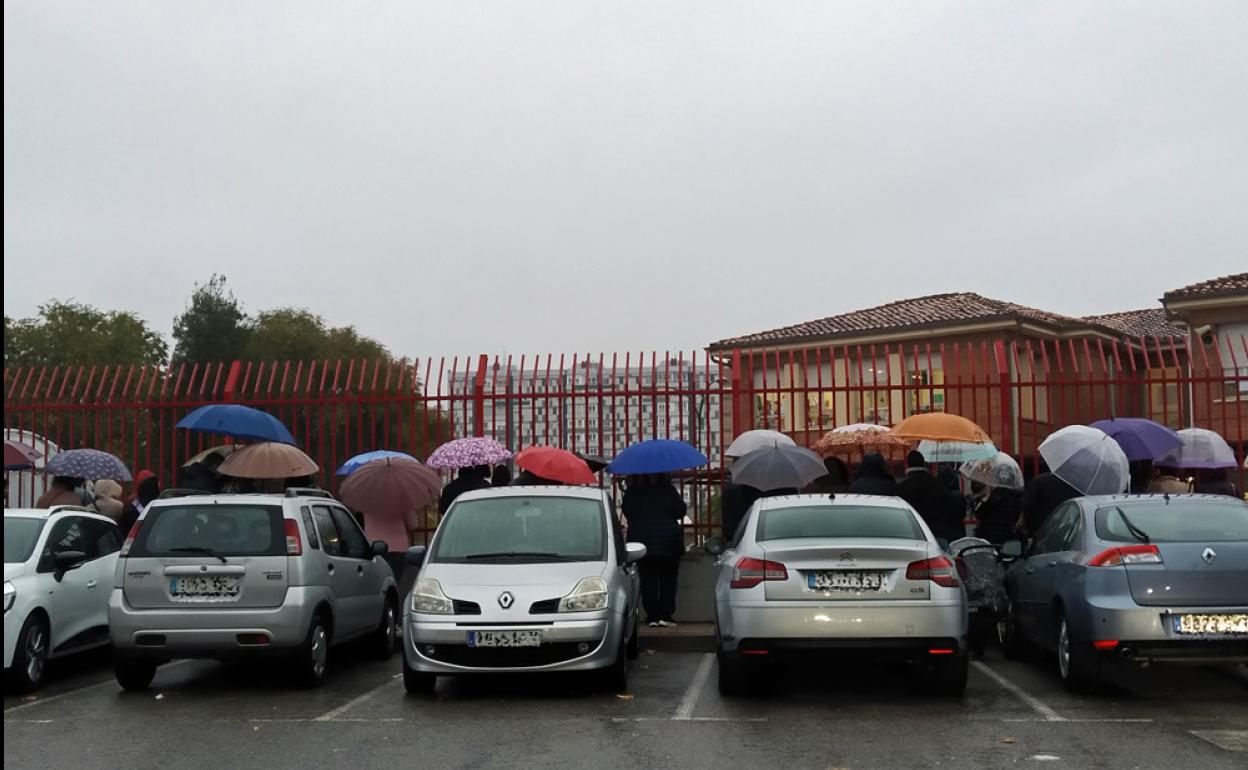 Los padres esperan a sus hijos, en un dia de lluvia, en el Juan de Vallejo.