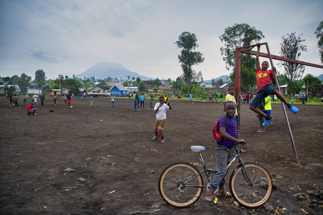 óvenes entranan al fútbol en Ngangi Don Bosco con el volcán Nyiragongo al fondo en Goma (Congo)