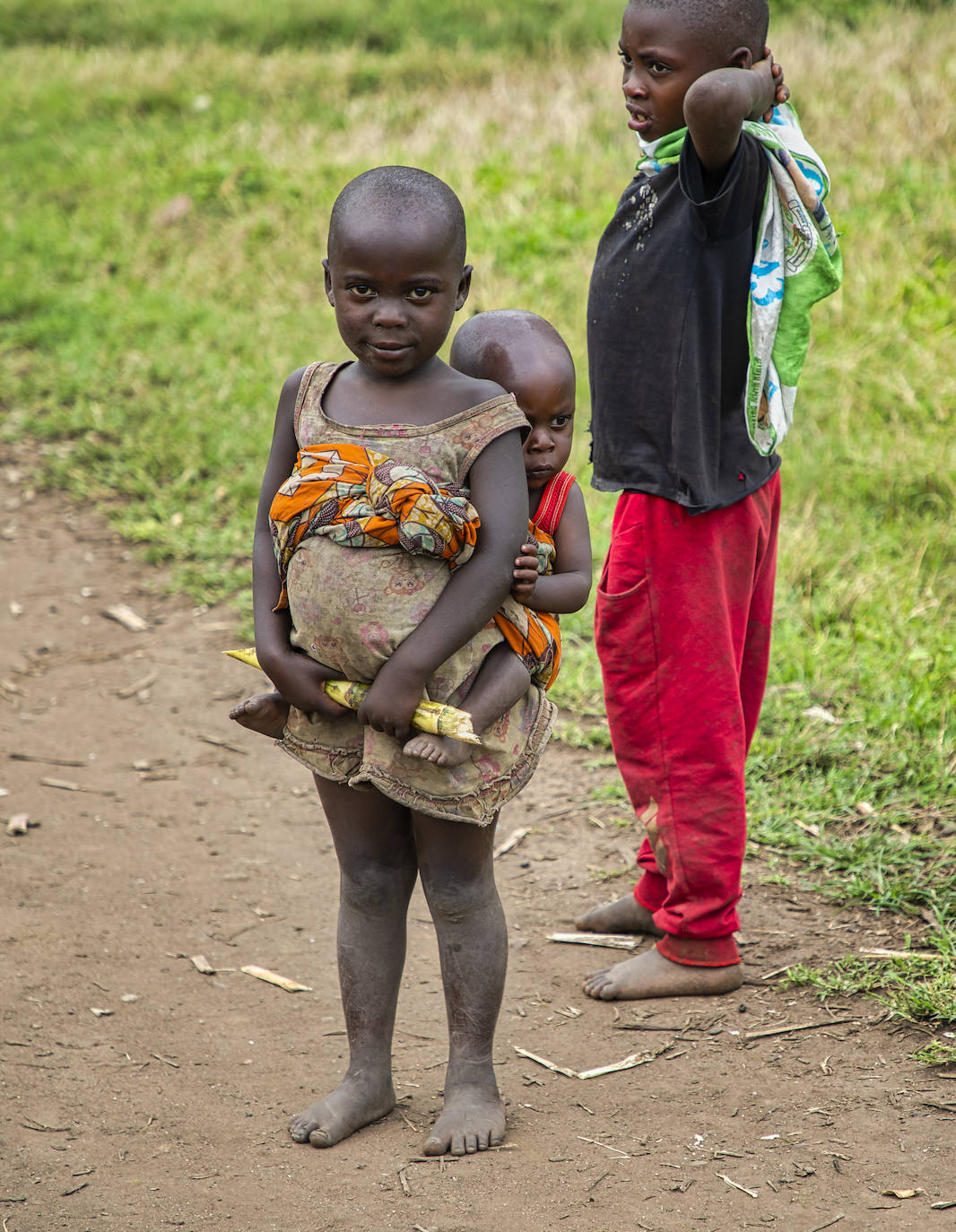 Una niña con su hermano pequeño vuelven de trabajar en el campo en Rubare (Congo), su único alimento un trozo de caña de azucar