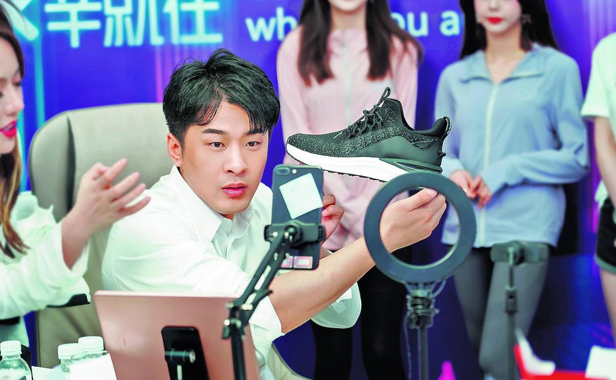 Xin Youzhi, fundador de la agencia Xinxuan, vende zapatos 