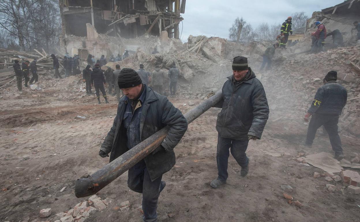 Unidos. La población ayuda a recoger material de una base militar ucraniana alcanzada por un misil ruso.