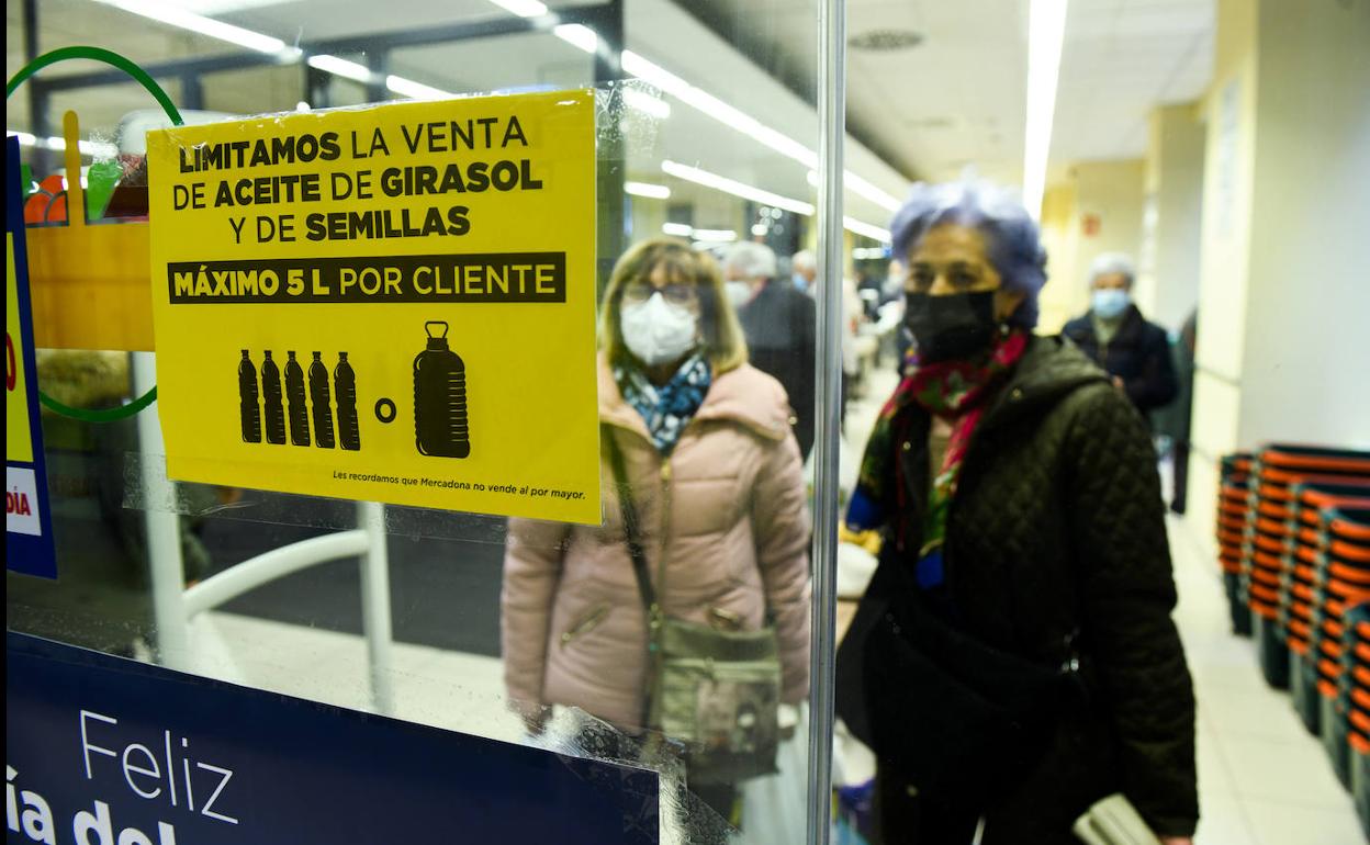 Dos clientas observan un cartel de un supermercado en el que informan de la limitación en la venta de aceite de girasol. 