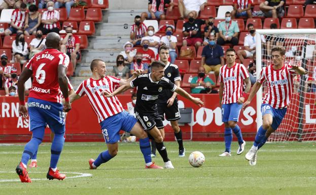 Raúl Navarro, rodeado de rivales del Sporting de Gijón en el partido de la primera vuelta.