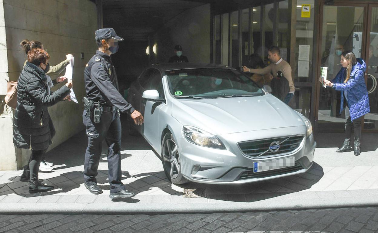 Familiares y amigos muestran carteles de Esther López al coche en el que Óscar salió del juzgado. 