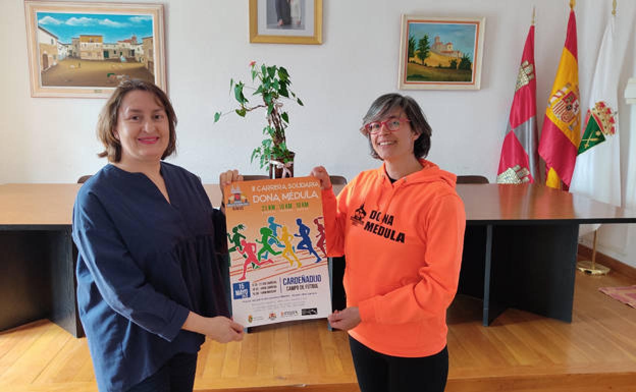 Mariela Grijalvo, alcaldesa de Cardeñadijo, (izda.) sostiene el cartel de la prueba, junto a un miembro de la orgtanización. 