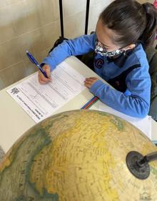 Imagen secundaria 2 - Arriba, un nuiño con su máscara de Carnaval, propio de Venecia; abajo a la izquierda, alumnos participan en el debate simulando las Naciones Unidas y a la derecha, una alumna junto a un globo terráqueo. 