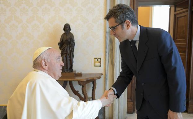 El papa Francisco, en la silla de ruedas que utiliza para desplazarse por sus problemas de rodilla, junto al ministro de la Presidencia, Félix Bolaños. 