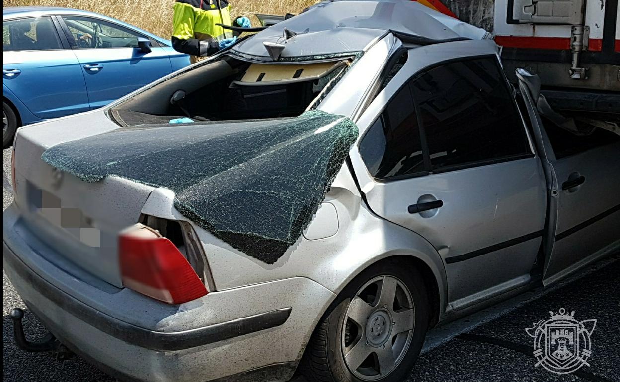 El turismo quedó atrapado bajo el camión. 