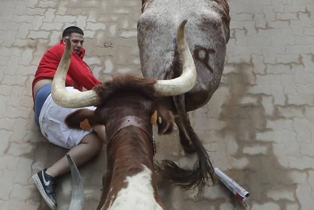 Los mozos, durante el octavo y último encierro de los Sanfermines con toros de la ganadería de Miura.