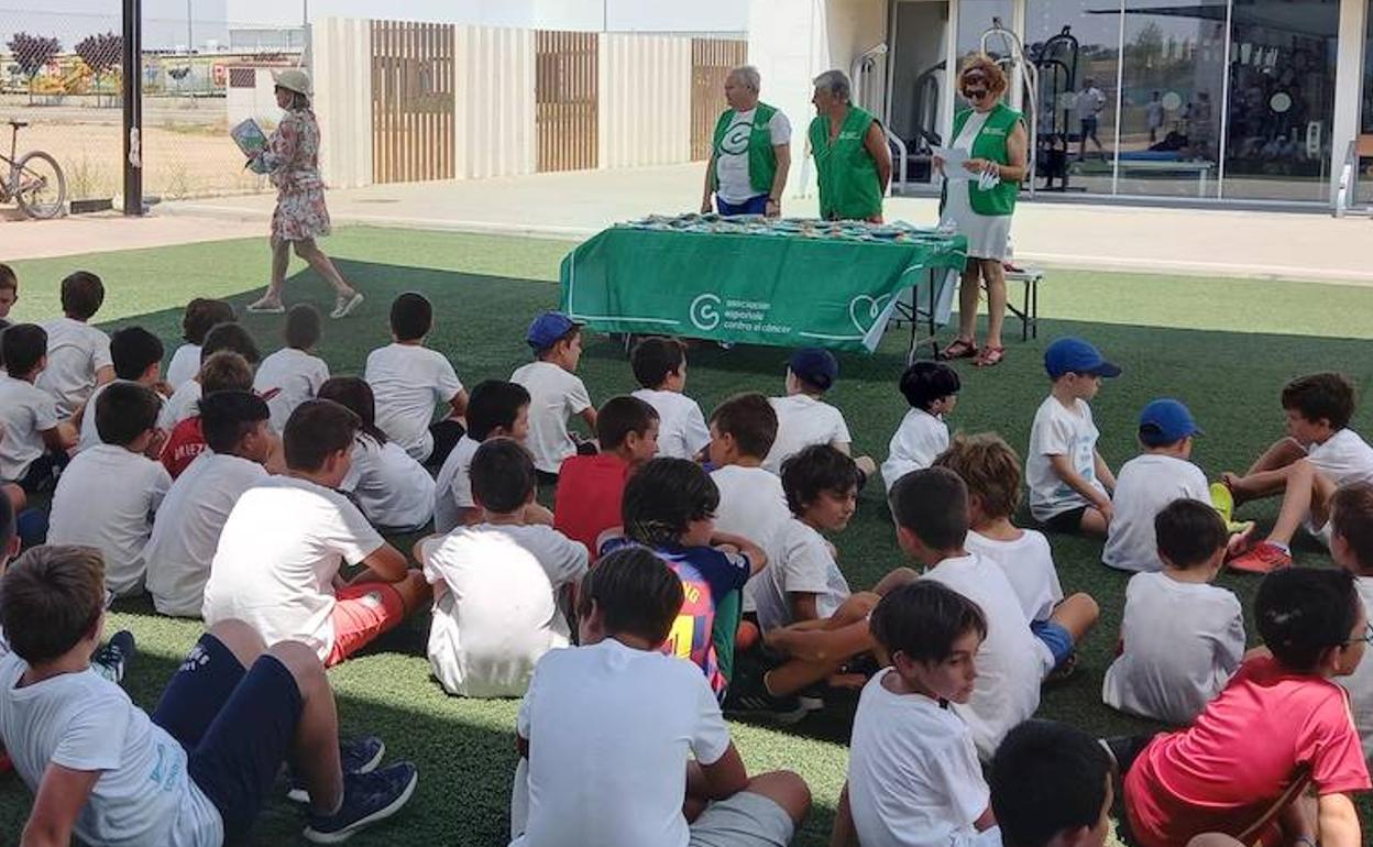 Miembros de AECC explican a los niños la importancia de una exposición solar adecuada