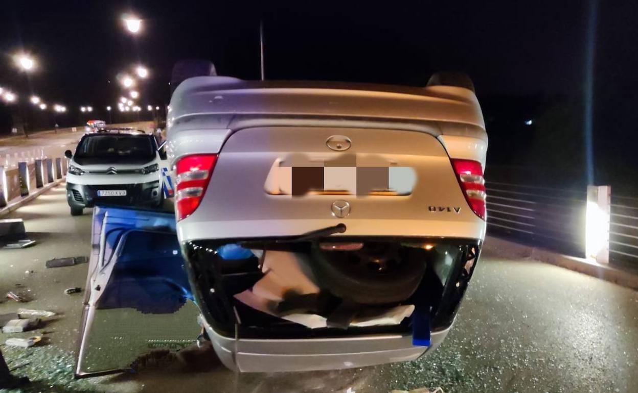 El coche volcado tras el accidente en el puente del barrio de Capiscol