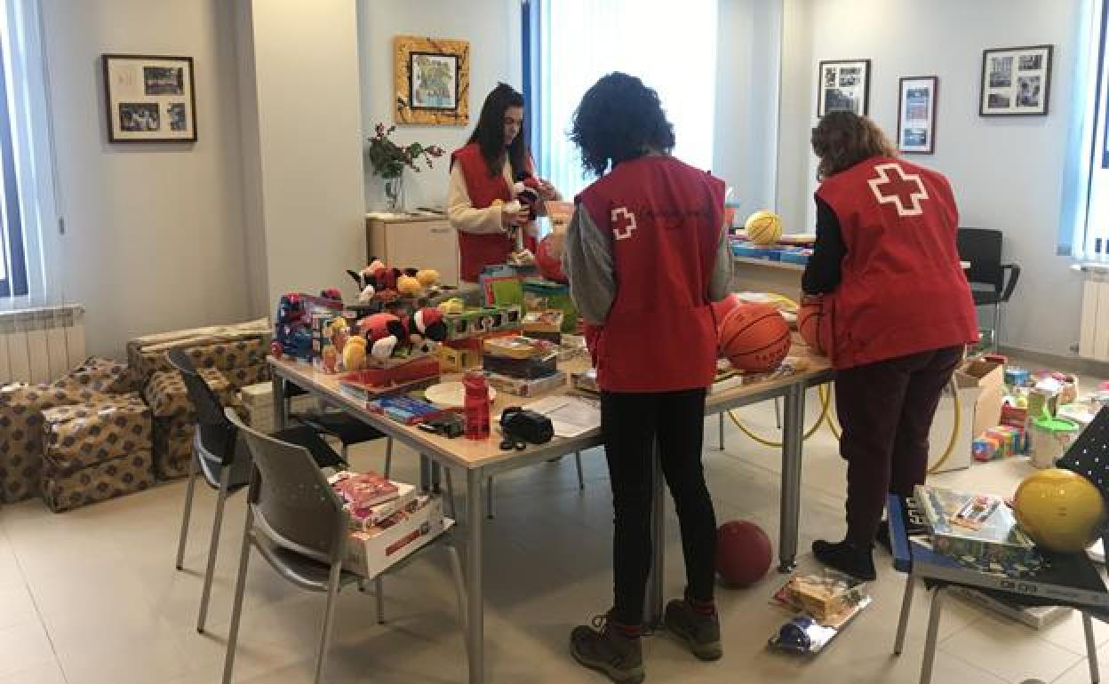 Voluntarios de Cruz Roja Juventud envuelven los juguetes donados. 