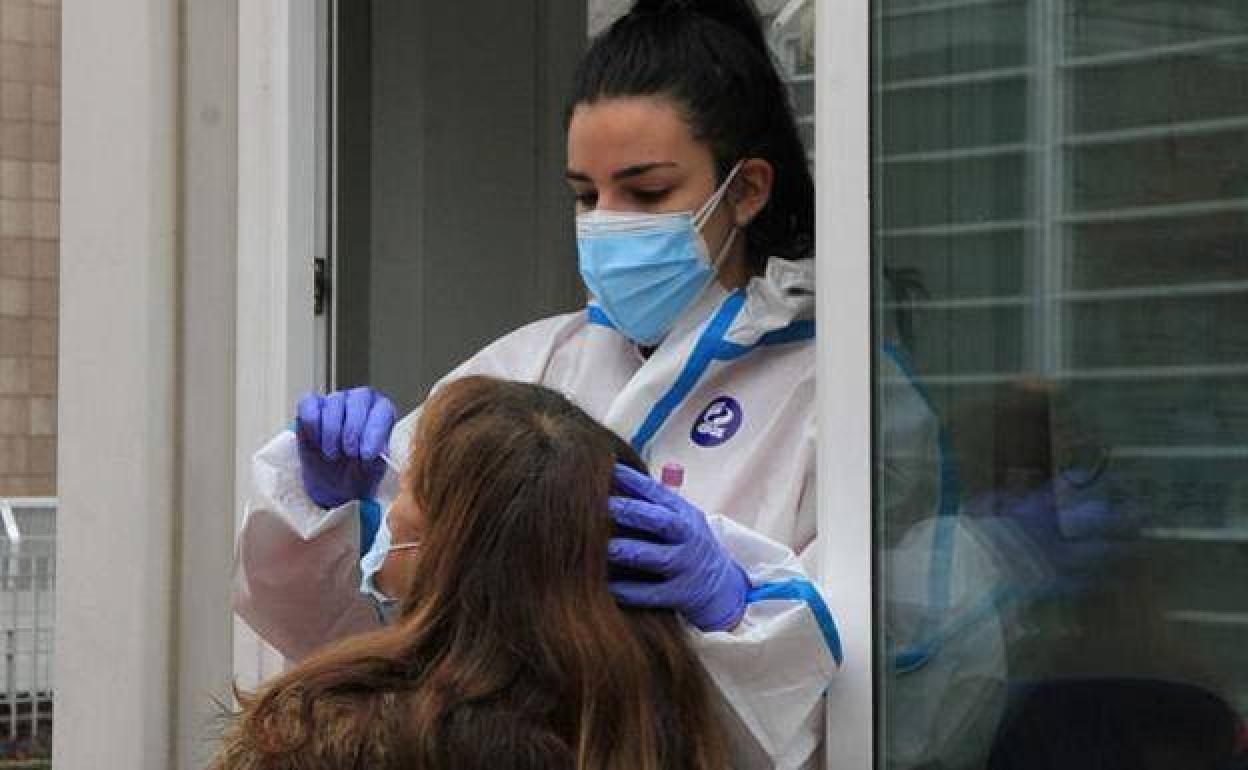 Personal sanitario realiza una prueba PCR a una mujer