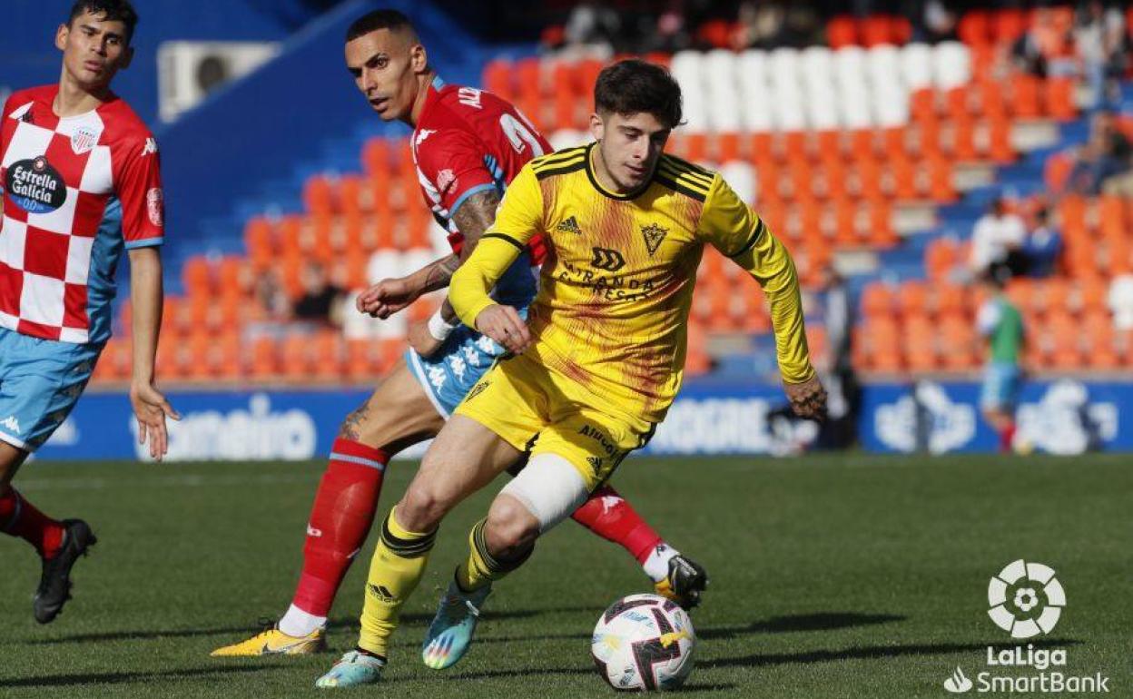 Nico Serrano conduce el balón tras dejar atrás a dos jugadores lucenses