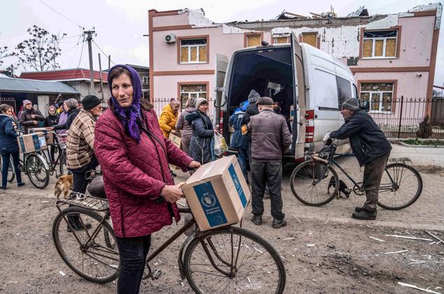 Una residente local monta su bicicleta después de recibir ayuda humanitaria en el pueblo liberado de Pravdyne, región de Jersón, el 12 de noviembre de 2022, en medio de la invasión rusa de Ucrania.