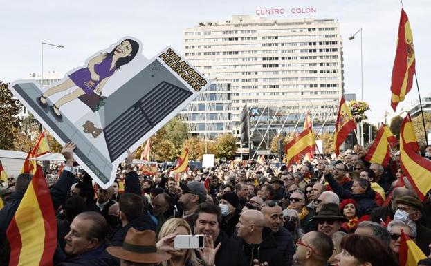 Imagen principal - 1. Pancarta en contra de la ministra Irene Montero. 2. Manifestantes de Vox portan un cartel exigiendo la celebración de elecciones. 3. Un vendedor ambulante ofrece banderas de España antes de la concentración. 