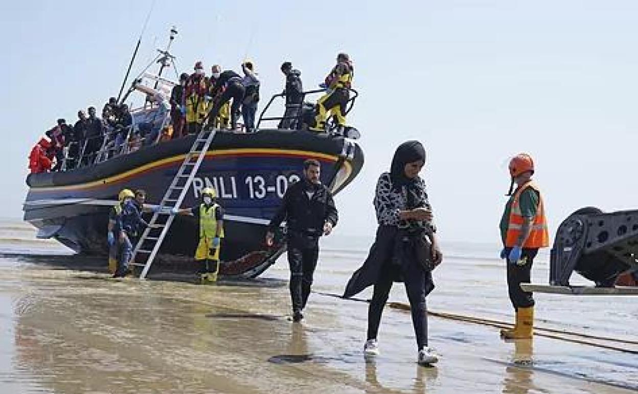 Un barco-patera desembarca a un grupo de inmigrantes en una playa inglesa tras hacer la travesía del Canal de la Mancha