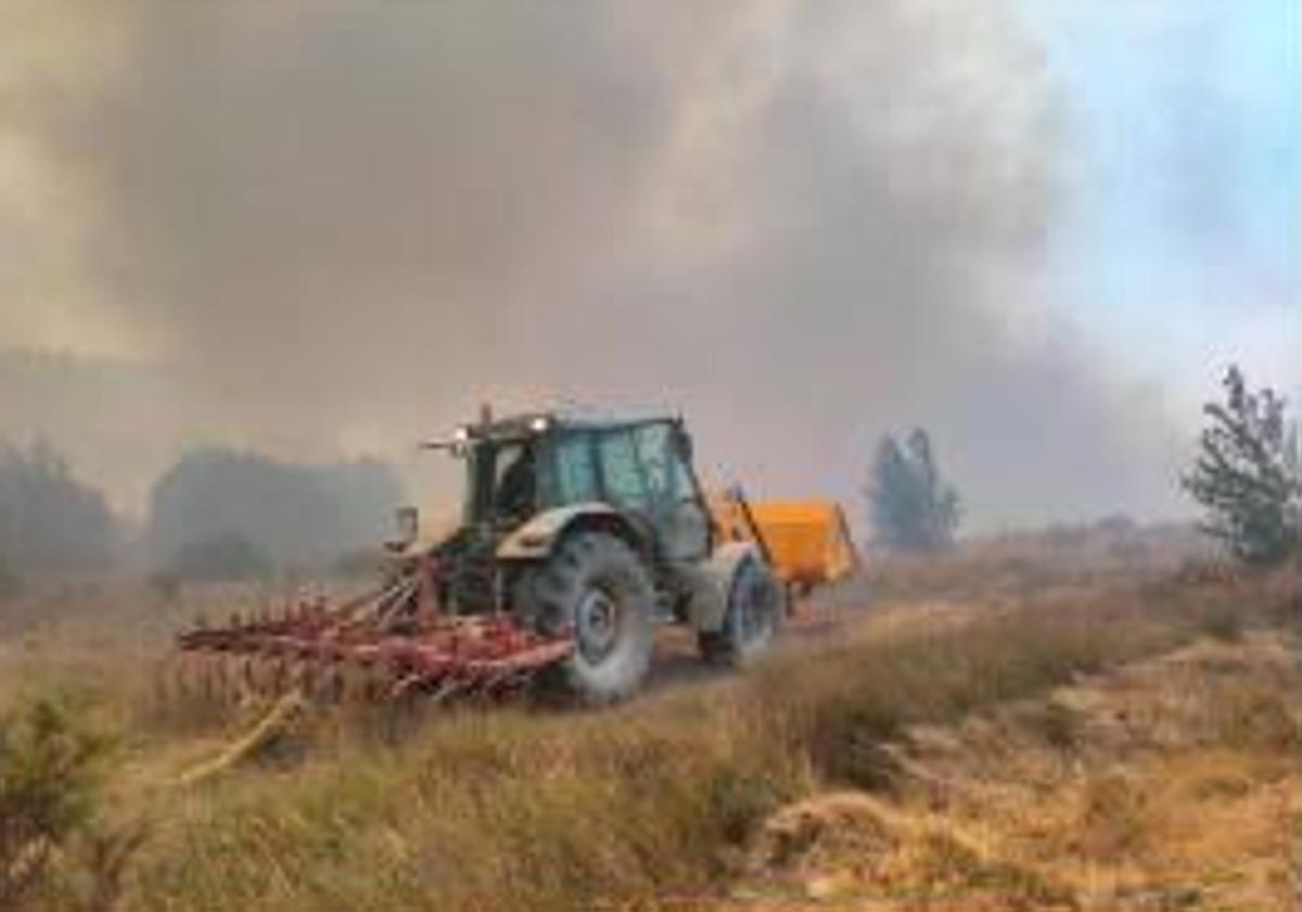 Un tractor colabora en la extinción del fuego de Quintanilla del Coco. Los agentes medioambientales aseguran que en ocasiones tienen que pedir ayuda a la ciudadanía.