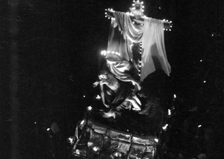 Imagen secundaria 1 - Costaleros de La Soledad junto al paso titular, el Descendimiento iluminado y cofrades y miembros de la Iglesia en la procesión del Viernes Santo de 1957