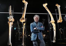 Juan Luis Arsuaga, posando con algunos de los nuevos fósiles expuestos en el MEH.