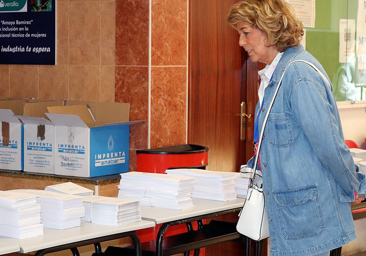 Una mujer consulta las papeletas en un colegio electoral.