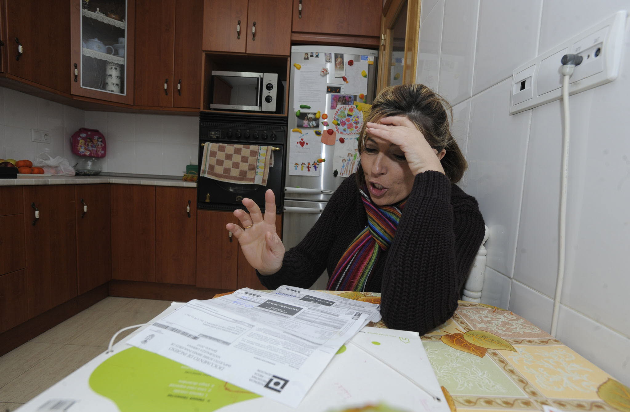 Una mujer observa las facturas del agua.