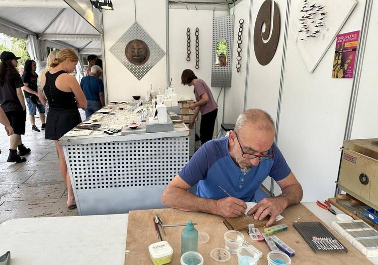 El artesano José Martín, del taller segoviano Jota Punto, trabaja la joyería junto a su puesto en el Paseo Marceliano Santamaría