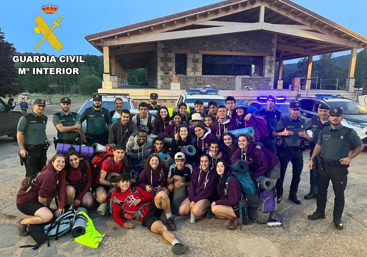 El grupo posa junto a los agentes de Guardia Civil que les rescataron tras su llegada al refugio