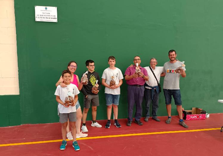 Imagen principal - Arriba, los ganadores con sus trofeos, junto al polideportivo que albergó la competición y una foto detalle de una de las partidas. 