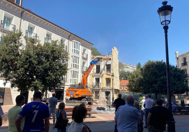 Los curiosos miran las obras desde la sombra