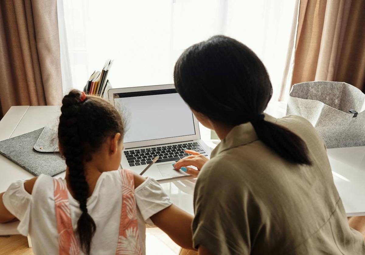 Madre ayudando a su hija con las tareas del colegio