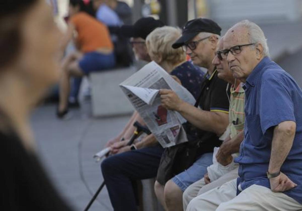 Varios hombres sentados en un banco.