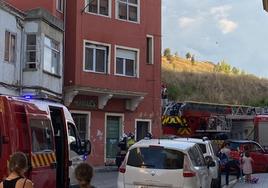 Los Bomberos de Burgos luchan contra las llamas en el incendio de una vivienda deshabitada en la calle Fray Esteban de la Villa ante la mirada de algunos vecinos