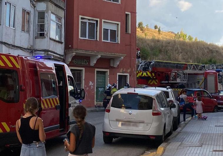 Los Bomberos de Burgos luchan contra las llamas en el incendio de una vivienda deshabitada en la calle Fray Esteban de la Villa ante la mirada de algunos vecinos