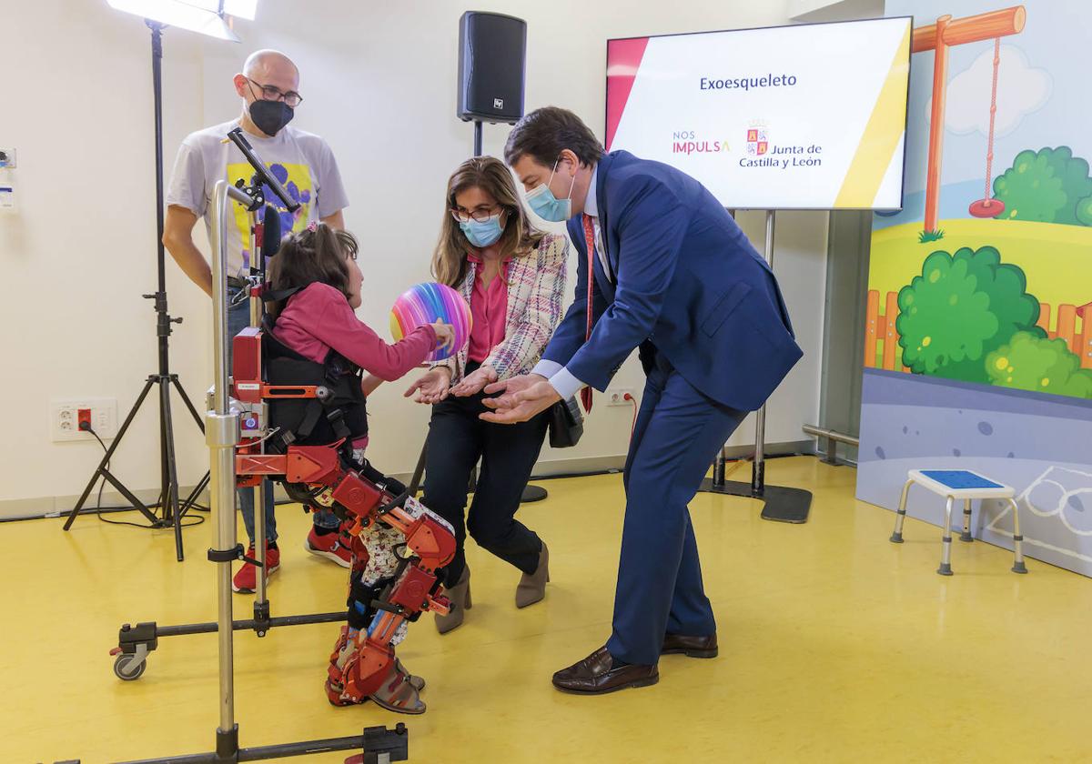 Lola, la niña que ha probado el exoesqueleto, junto al presidente de la Junta Alfonso Fernández Mañueco.