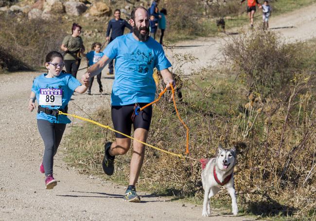 Dos deportistas junto a su perro durante una carrera