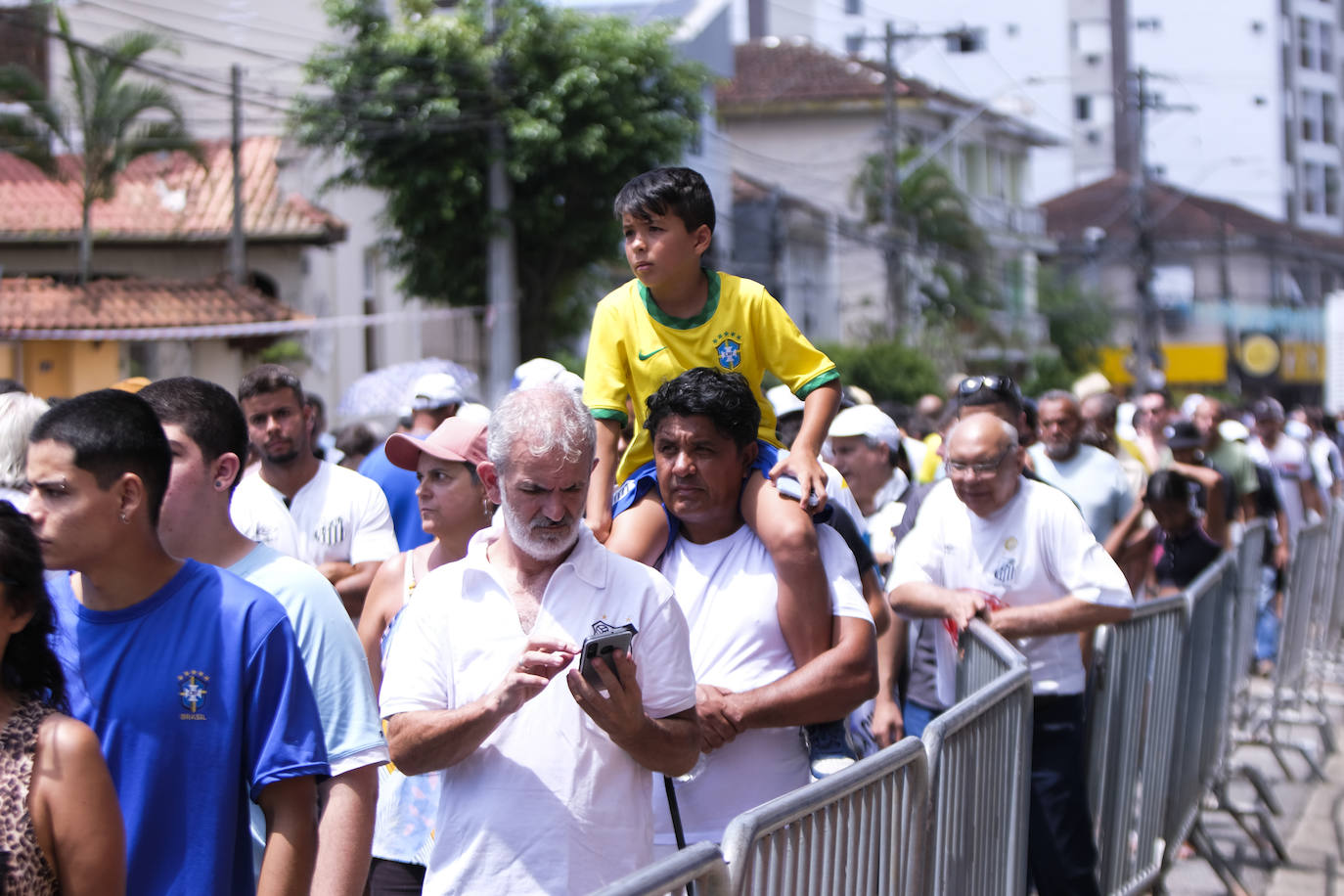 Cientos de personas hacen cola para asistir al velorio de Pelé en el estadio del Santos. 