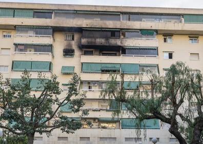 Imagen secundaria 1 - En la imagen superior, los bomberos en la terraza del piso donde comenzó el fuego; debajo, vista de la fachada del edificio de Fuengirola en la que se observa como el incendio terminó dañando parte de los pisos superiores; por último, varios policías vigilan los acceso al lugar de los hechos.