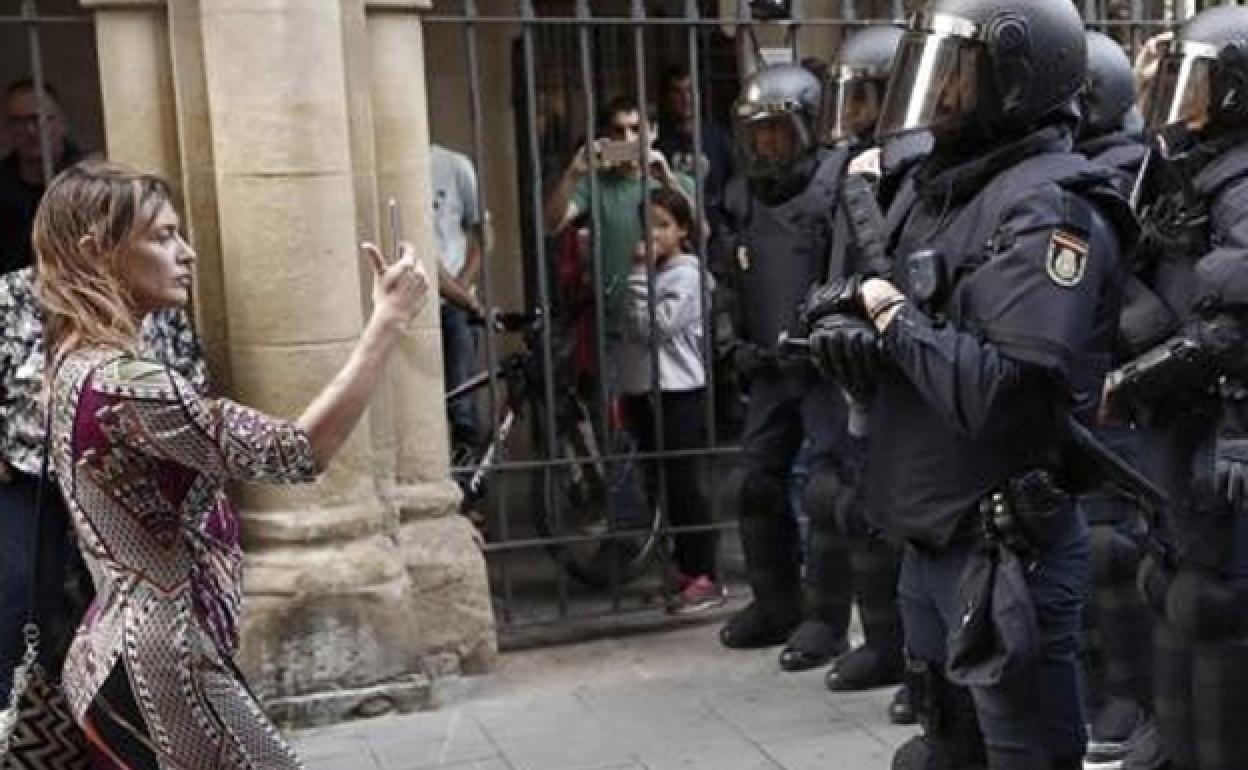 Una mujer graba a un grupo de antidisturbios durante una protesta en Pamplona