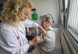 Un hombre recibe la vacuna contra la gripe.