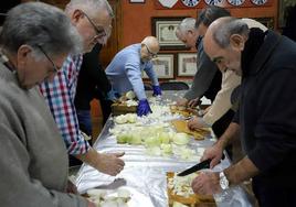 Los cofrades y colaboradores se afanan en cortar cebolla.