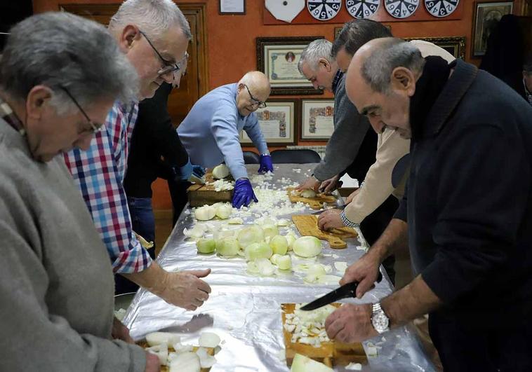 Los cofrades y colaboradores se afanan en cortar cebolla.