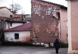 Una mujer camina por Villangómez donde se puede leer el nombre del festival Pollogómez.