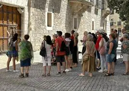 Una guía explica el Palacio de los Condestables de Castilla -o Casa del Cordón- a un grupo de turistas este verano en Burgos