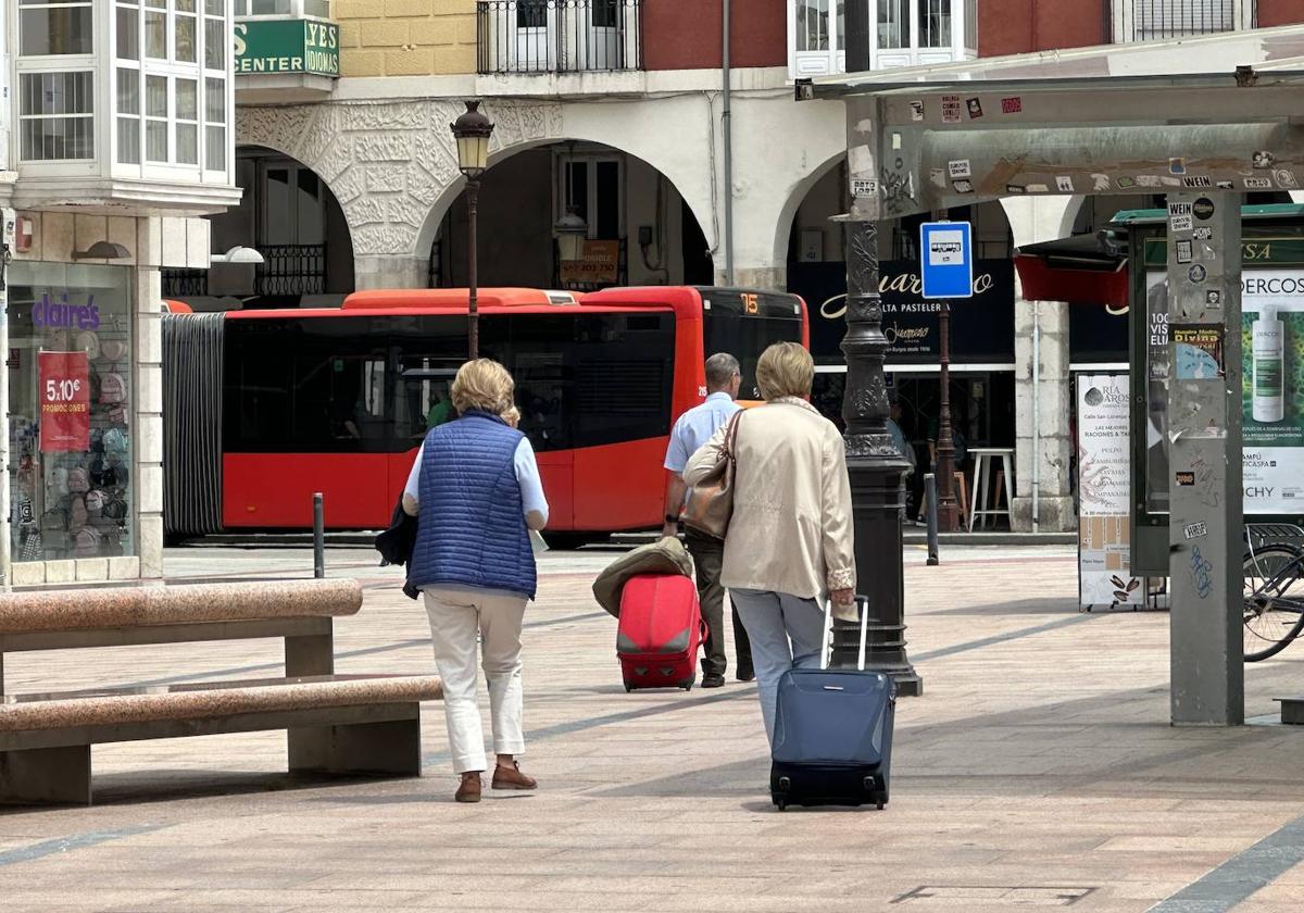 Varias personas portan sus maletas por el centro de Burgos