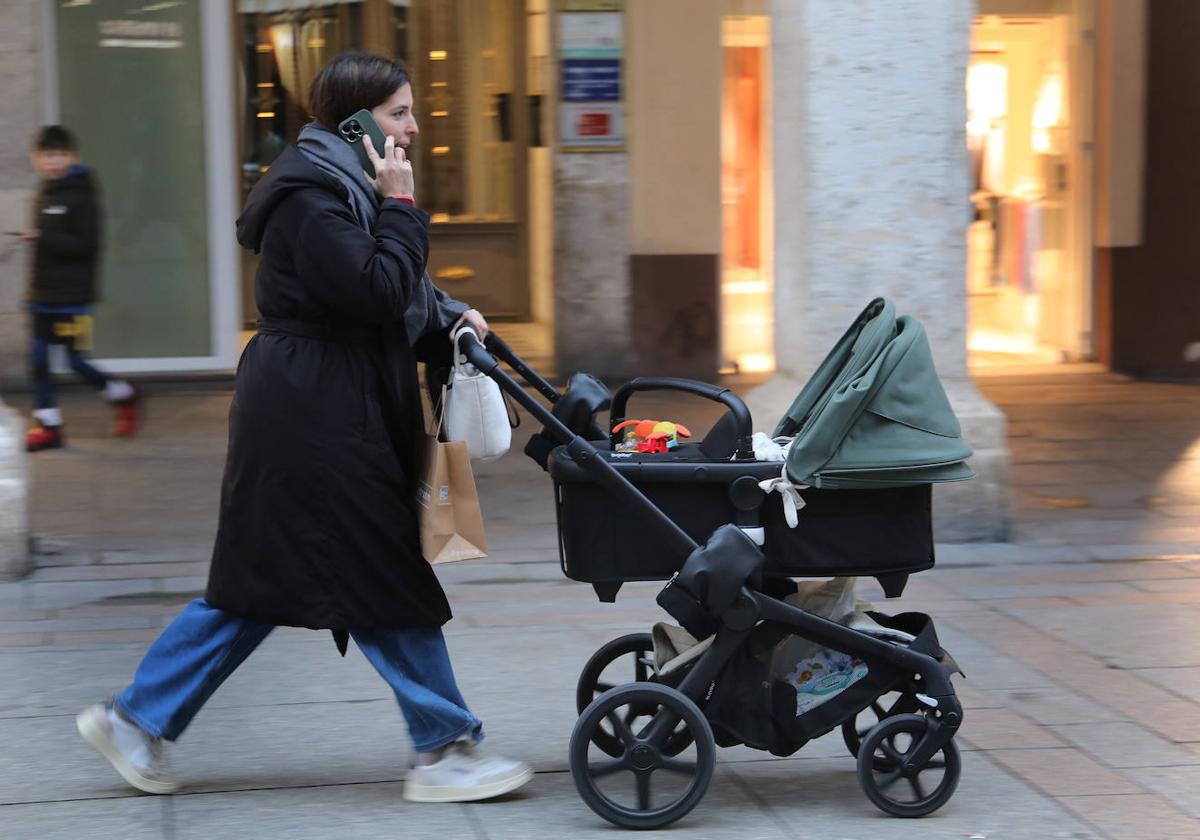 Imagen de una madre llevando a su hijo por la calle.