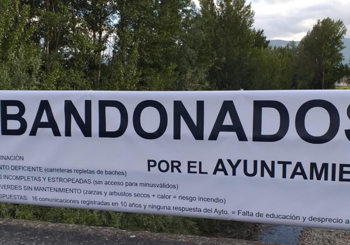 «Abandonados por el Ayuntamiento», reza la pancarta instalada por los vecinos de esta urbanización de Medina de Pomar.