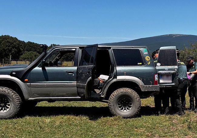 Agentes de la Guardia Civil meten al hombre en un vehículo todoterreno particular para poder evacuarlo del lugar de difícil acceso donde lo encontraron.