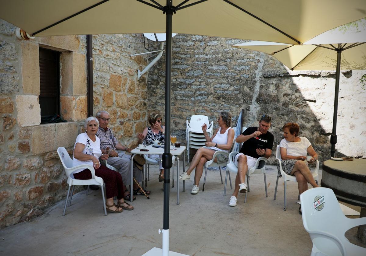 Imagen principal - Vecinos en la terraza de la cantina de Quintanilla de las Viñas. 